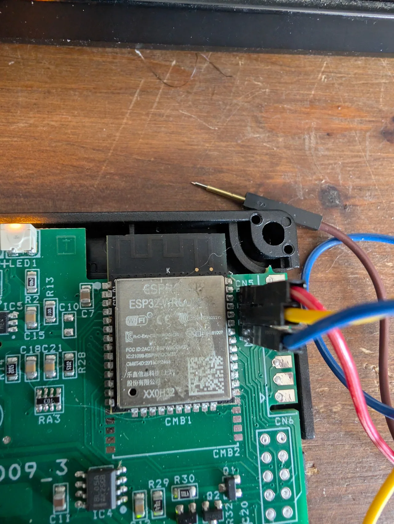Trois dupont femelles maintenus sur CN5 pendant le dump : rouge sur pin 1 GND, jaune sur pin 2 TX module, bleu sur pin 3 RX module ; ESP32-WROOM-32 label lisible juste à côté
